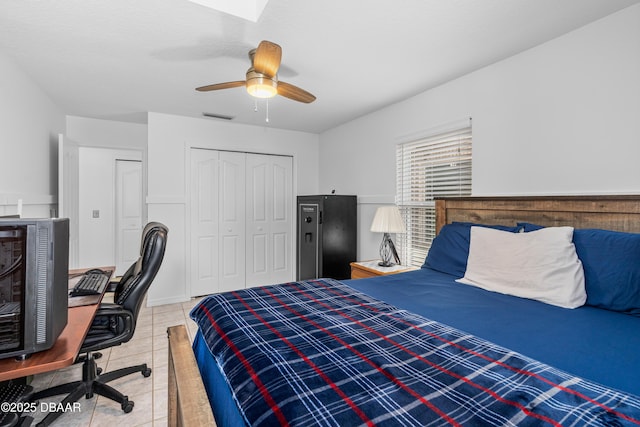 tiled bedroom with ceiling fan and a closet