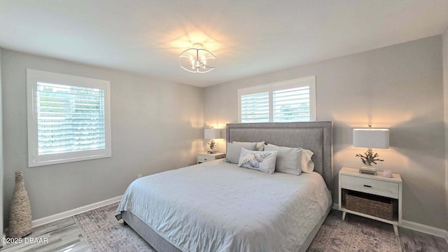 70 Ocean Shore Dr, Ormond Beach, FL 32176 - bedroom with multiple windows, a chandelier, and baseboards