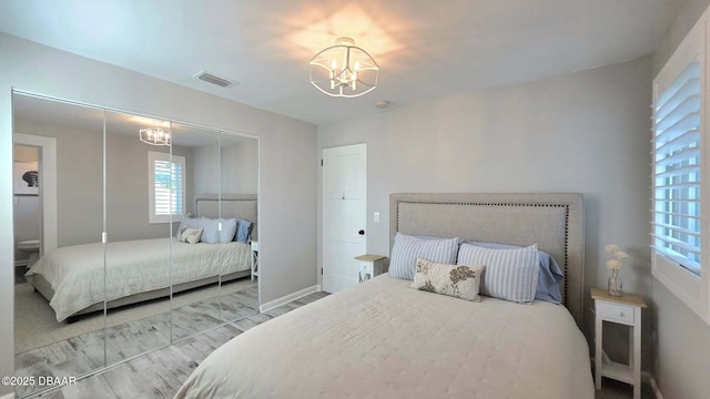 70 Ocean Shore Dr, Ormond Beach, FL 32176 - bedroom featuring a chandelier, baseboards, a closet, and wood finished floors