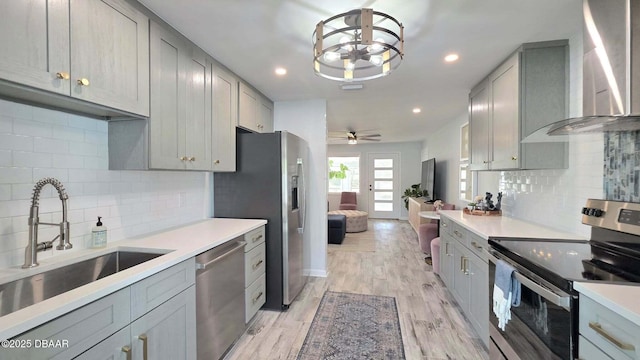 70 Ocean Shore Dr, Ormond Beach, FL 32176 - kitchen featuring stainless steel appliances, gray cabinets, wall chimney range hood, a sink, and light countertops