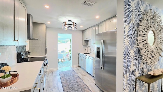 70 Ocean Shore Dr, Ormond Beach, FL 32176 - kitchen with appliances with stainless steel finishes, a sink, light countertops, wall chimney exhaust hood, and recessed lighting
