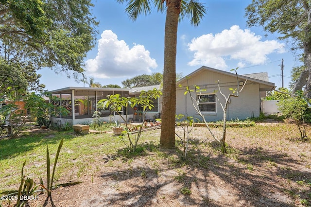 88 Cindy Ln, Ponce Inlet, FL 32127 - rear view of property with a sunroom