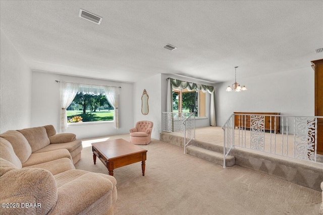 carpeted bedroom featuring multiple windows, a notable chandelier, and a textured ceiling