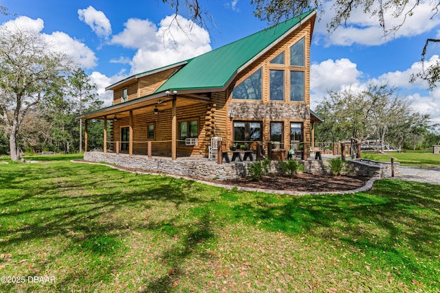 rear view of property featuring log exterior, ceiling fan, metal roof, and a lawn