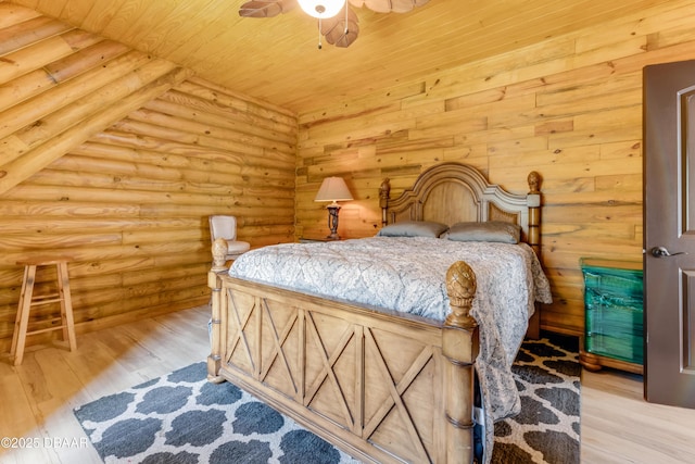 bedroom with rustic walls, wooden ceiling, and wood finished floors