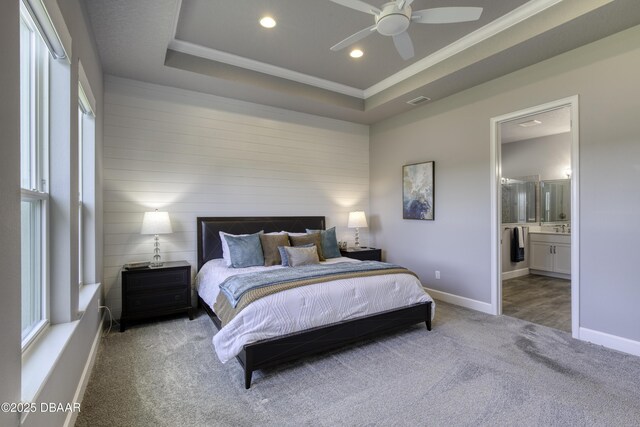 carpeted bedroom featuring a tray ceiling, ceiling fan, and crown molding