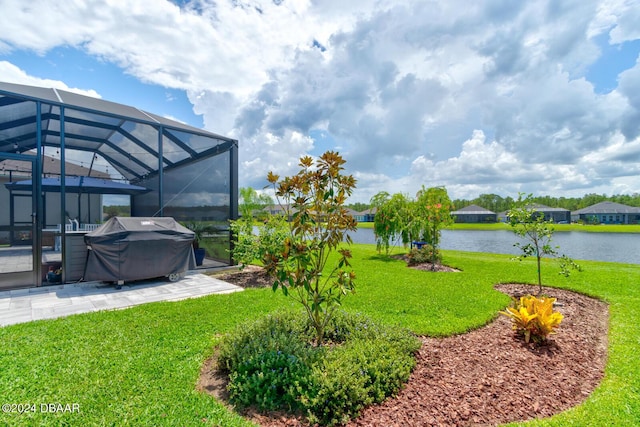 view of yard with glass enclosure, a water view, and a patio