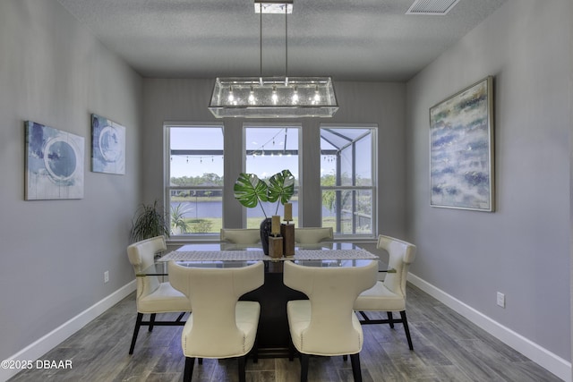 dining area featuring a textured ceiling and dark hardwood / wood-style flooring