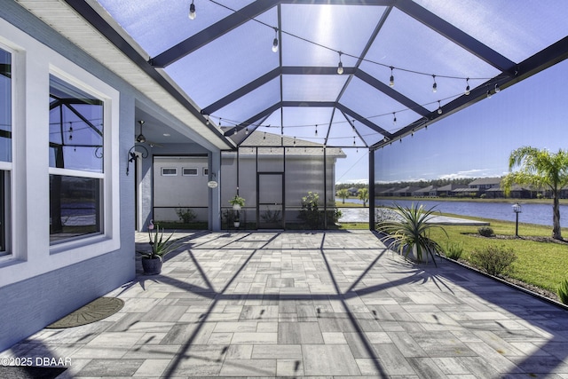 view of patio / terrace with a water view and glass enclosure