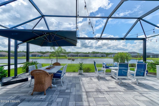 view of patio featuring a water view and glass enclosure