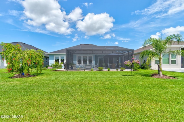 rear view of property with a lawn and glass enclosure