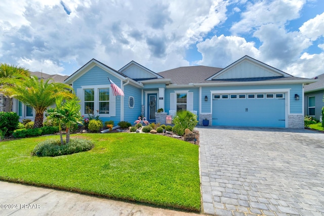 craftsman house with a garage and a front lawn