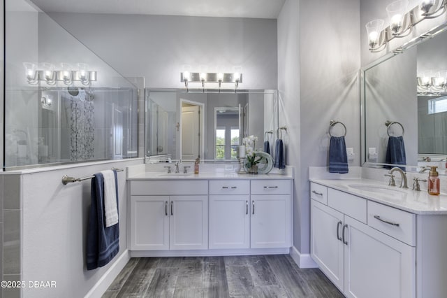 bathroom with vanity, hardwood / wood-style floors, and a shower with door