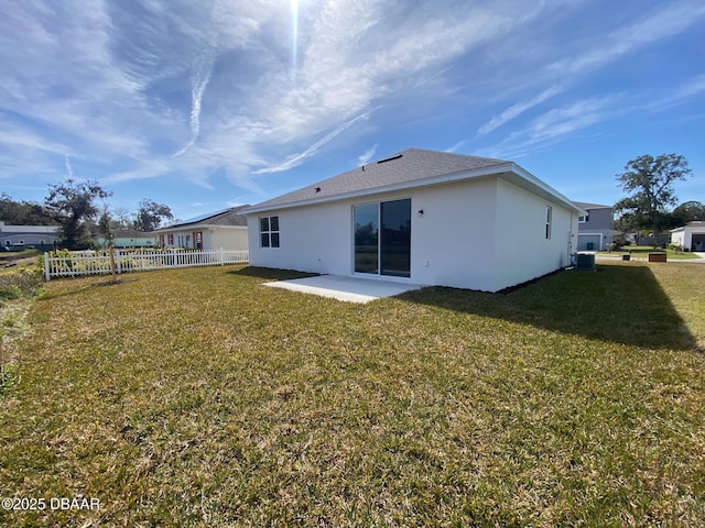 back of house with a patio, a lawn, fence, and stucco siding