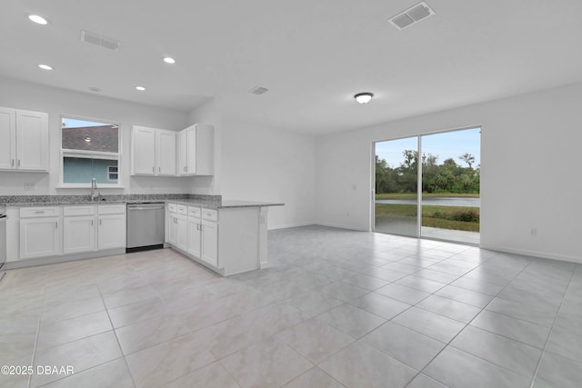 kitchen featuring visible vents, white cabinets, light stone countertops, dishwasher, and a peninsula