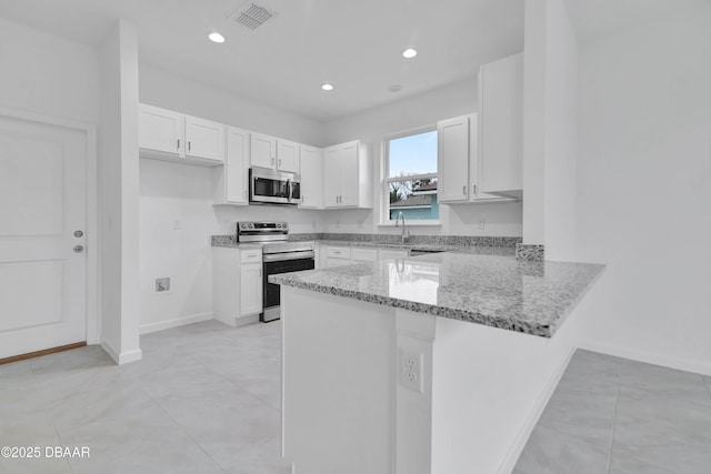 kitchen featuring visible vents, white cabinets, a peninsula, light stone countertops, and stainless steel appliances