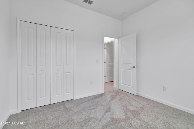 unfurnished bedroom with a closet, carpet flooring, visible vents, and baseboards