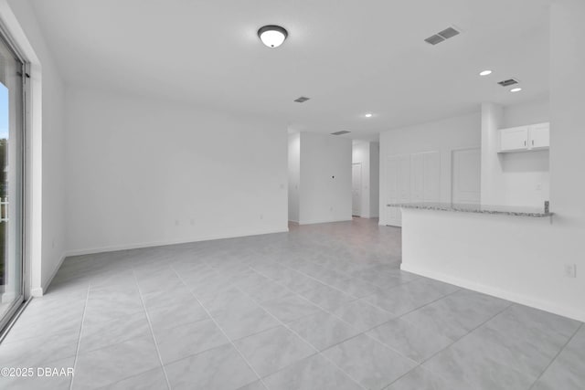 spare room featuring recessed lighting, visible vents, and baseboards