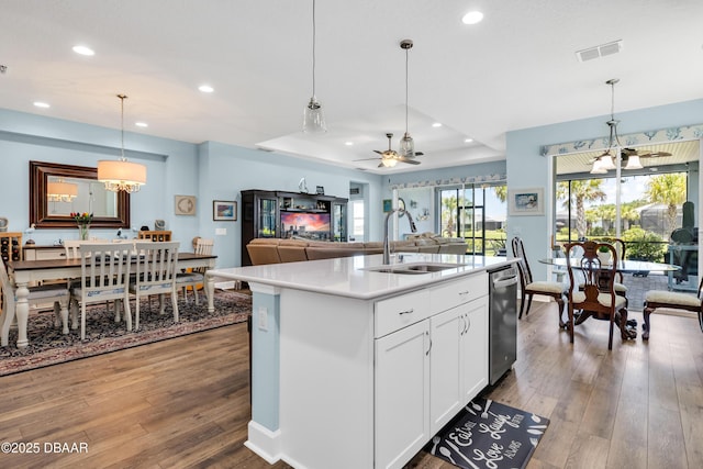 kitchen with a center island with sink, ceiling fan with notable chandelier, white cabinets, sink, and decorative light fixtures