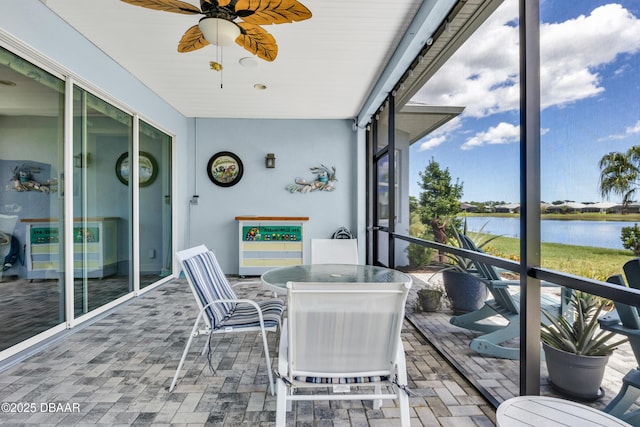 sunroom / solarium featuring ceiling fan and a water view