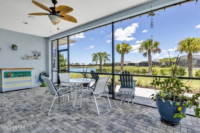 sunroom with a water view and ceiling fan