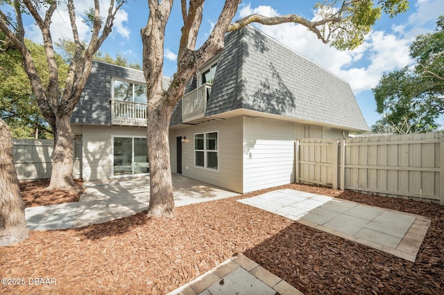 rear view of property featuring a patio and a balcony