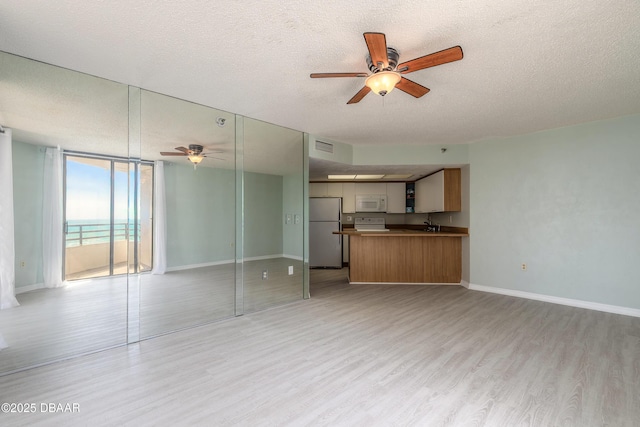 unfurnished living room featuring light wood-type flooring, a textured ceiling, and ceiling fan