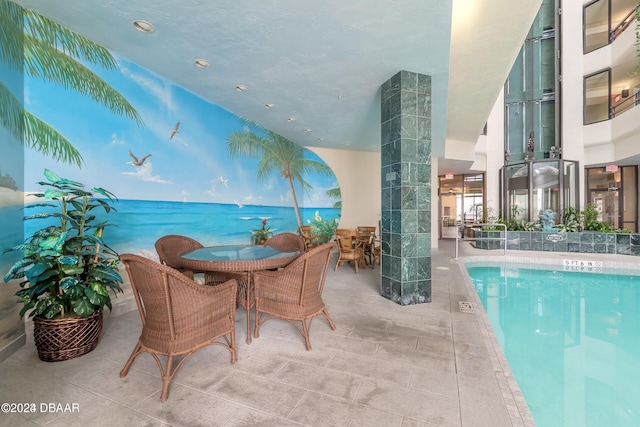 community pool featuring outdoor dining area and a patio area