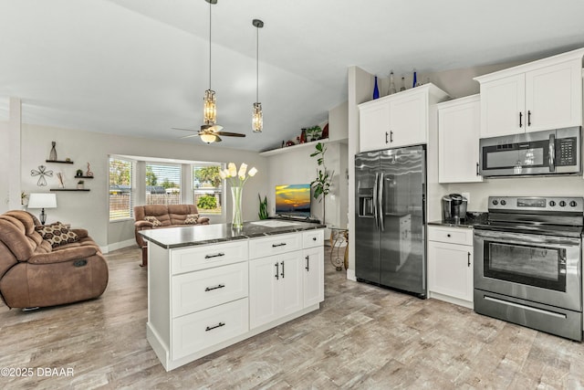 kitchen with dark countertops, light wood-style flooring, stainless steel appliances, and open floor plan