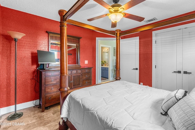 bedroom with ceiling fan, visible vents, wood finished floors, and ornamental molding