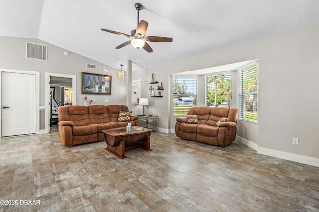 living area with vaulted ceiling, wood finished floors, visible vents, and baseboards