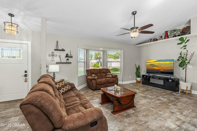 living room with baseboards, vaulted ceiling, wood finished floors, and ceiling fan with notable chandelier