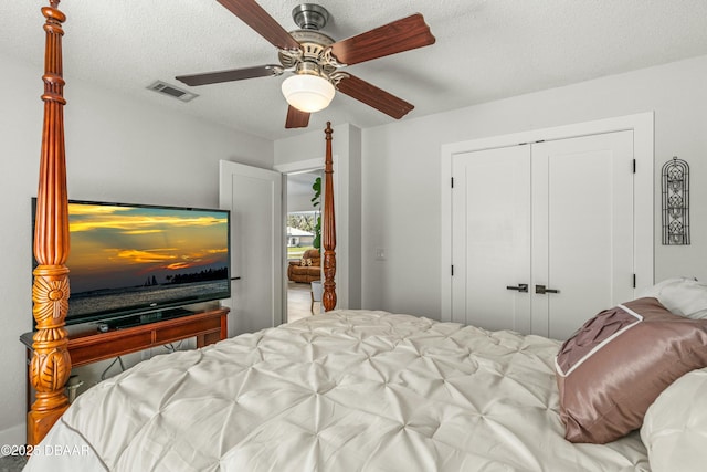 bedroom featuring a closet, visible vents, ceiling fan, and a textured ceiling