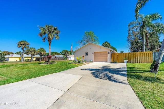 view of front of property with an attached garage, fence, concrete driveway, stucco siding, and a front yard