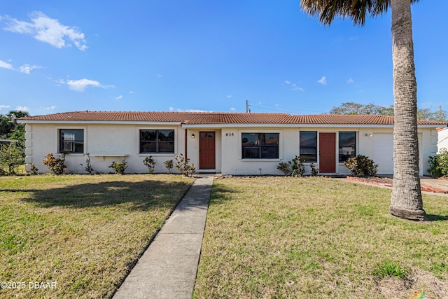 ranch-style house featuring a garage and a front lawn