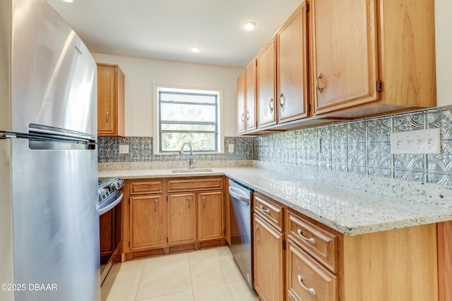 kitchen featuring sink, tasteful backsplash, light tile patterned floors, stainless steel appliances, and light stone countertops