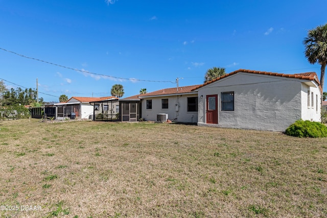 back of property featuring central AC, a sunroom, and a lawn