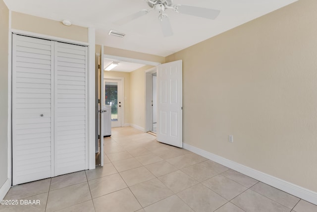 unfurnished bedroom with light tile patterned floors, a closet, and ceiling fan