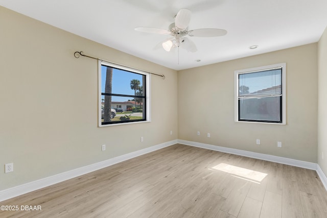 empty room with ceiling fan and light hardwood / wood-style flooring