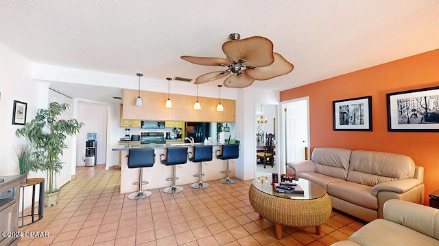 living room featuring sink, light tile patterned floors, and ceiling fan