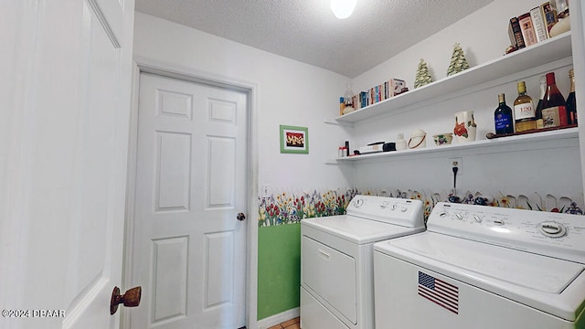 washroom featuring a textured ceiling and washing machine and clothes dryer