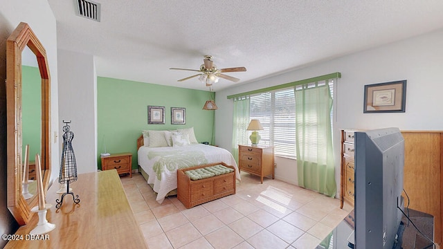 bedroom featuring a textured ceiling, light tile patterned floors, and ceiling fan