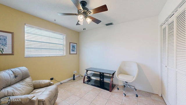 sitting room with ceiling fan and light tile patterned floors