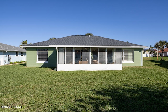 rear view of property featuring a sunroom and a lawn