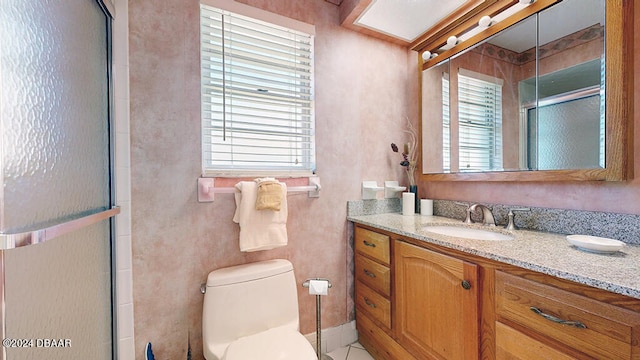 bathroom featuring toilet, an enclosed shower, vanity, and a healthy amount of sunlight