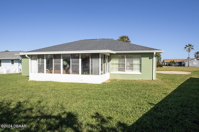 back of house featuring a sunroom and a lawn