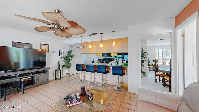 kitchen featuring black appliances, hanging light fixtures, a breakfast bar, kitchen peninsula, and ceiling fan