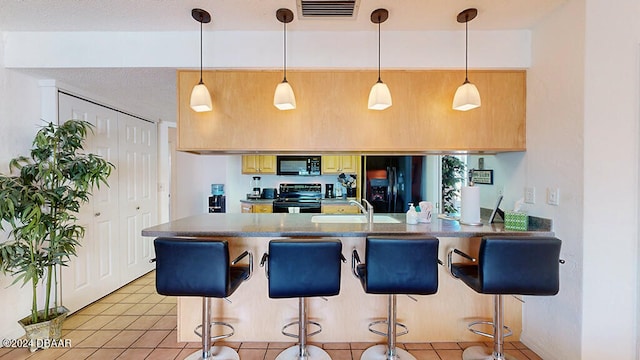 kitchen with sink, black appliances, kitchen peninsula, a breakfast bar area, and decorative light fixtures