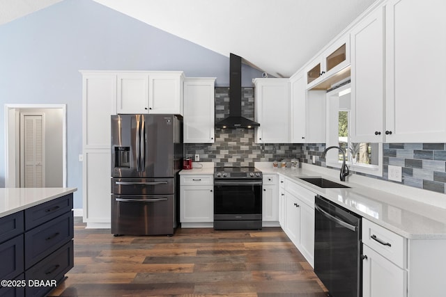 kitchen featuring lofted ceiling, wall chimney range hood, sink, white cabinetry, and appliances with stainless steel finishes