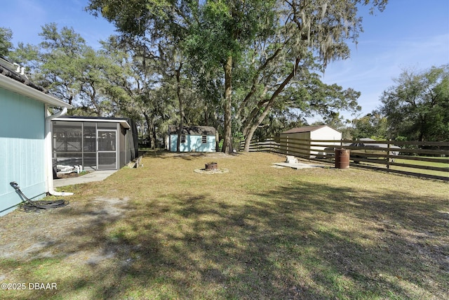 view of yard featuring a storage unit and a sunroom